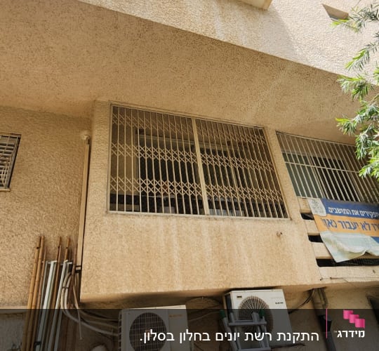סולם ליד מזגנים על קיר בניין